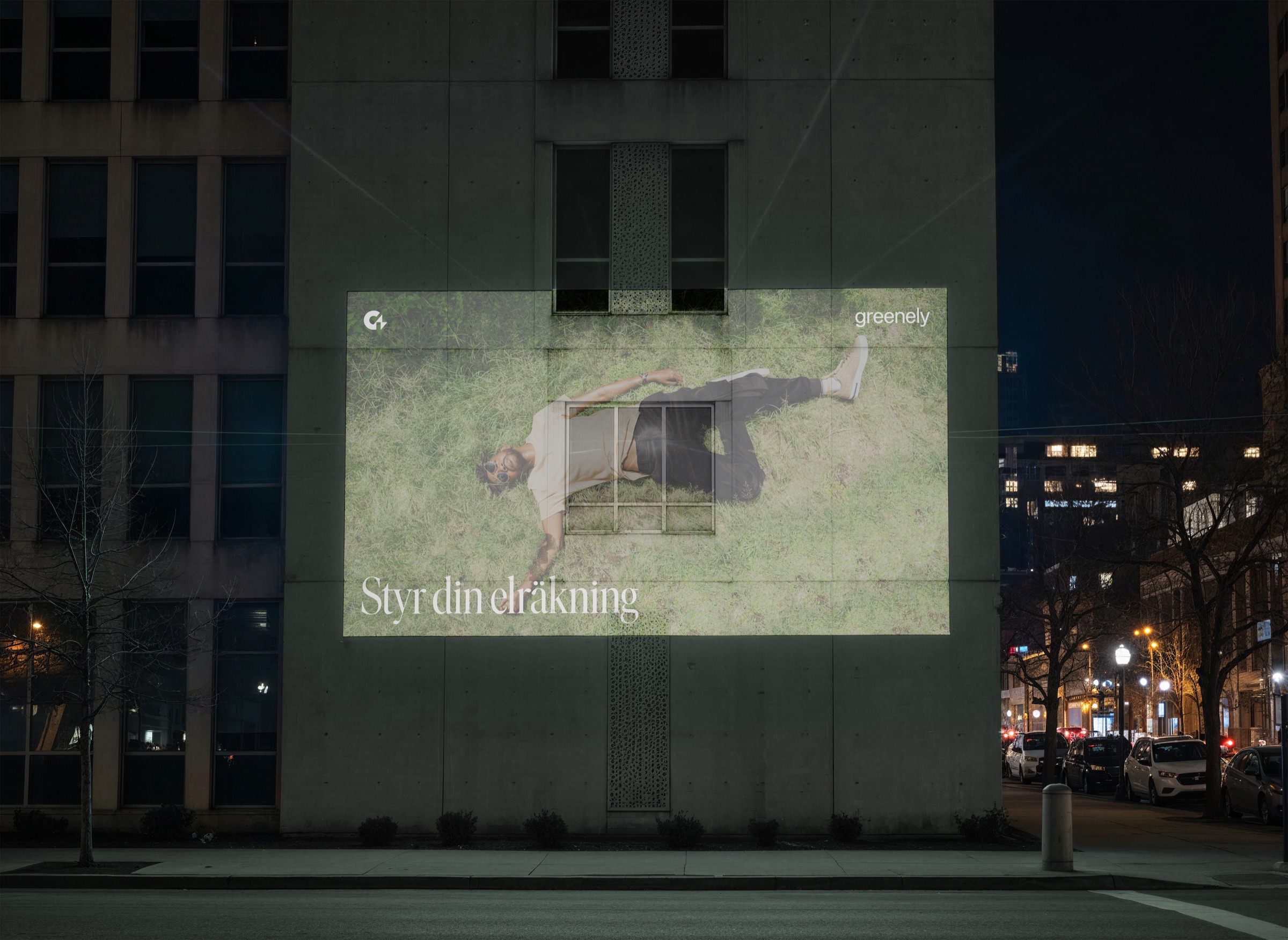 Greenely campaign projected on a building at night